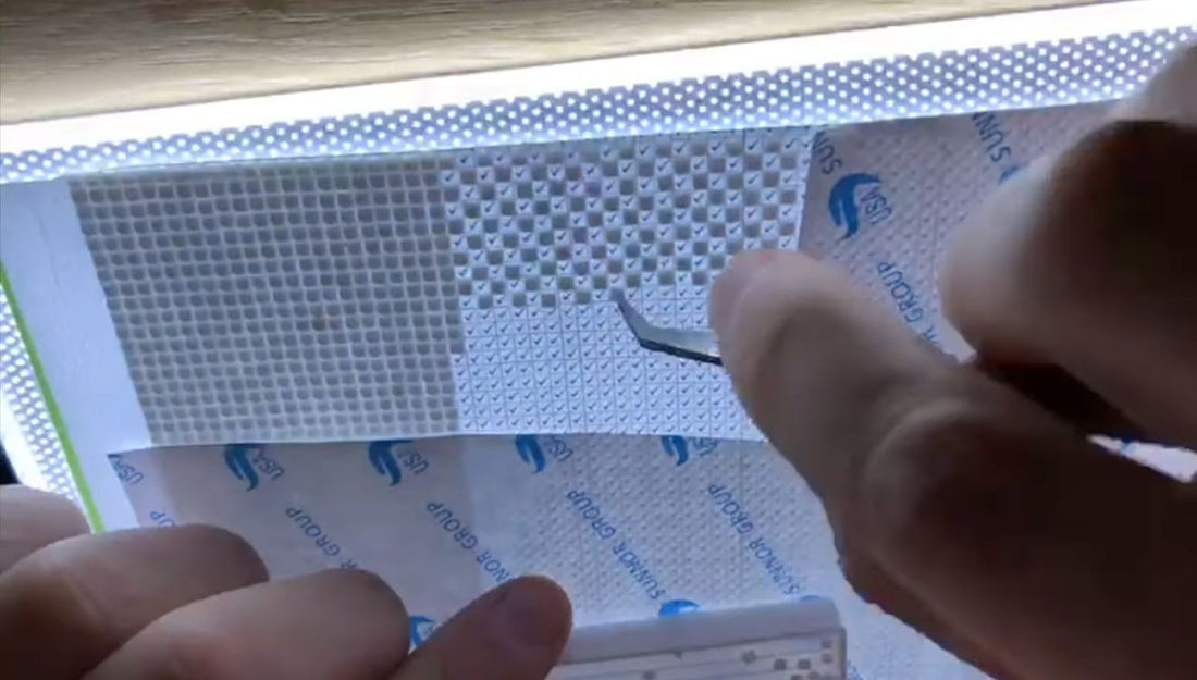 Vierkante diamond-paintingsteentjes in een afwisselend patroon op een verlicht canvas