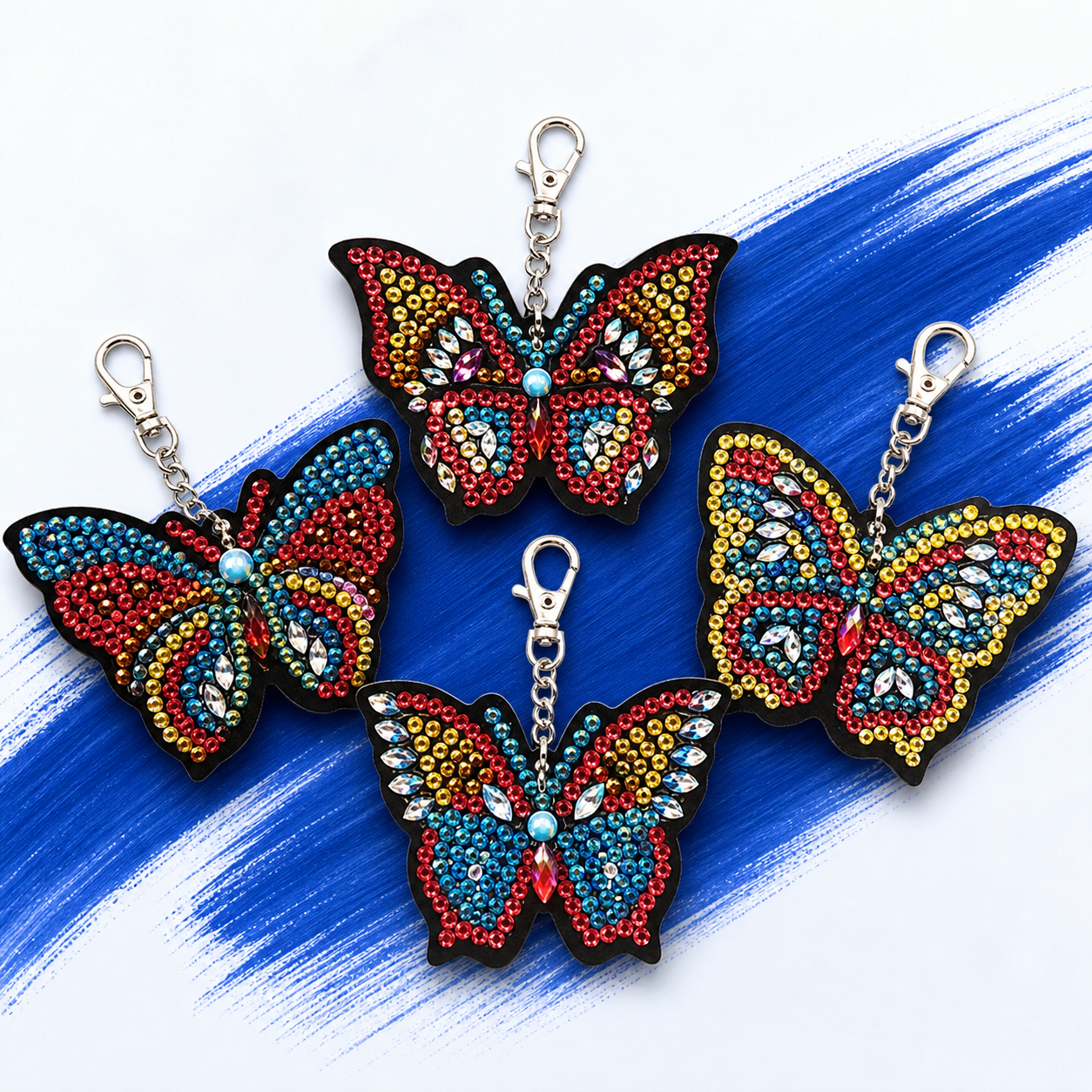 Vier diamond painting sleutelhangers met kleurrijke vlinders